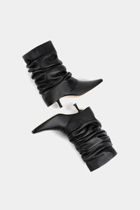 Bota negra suave de tacto cuero, caña abullonada y tacón fino de 4 cm
